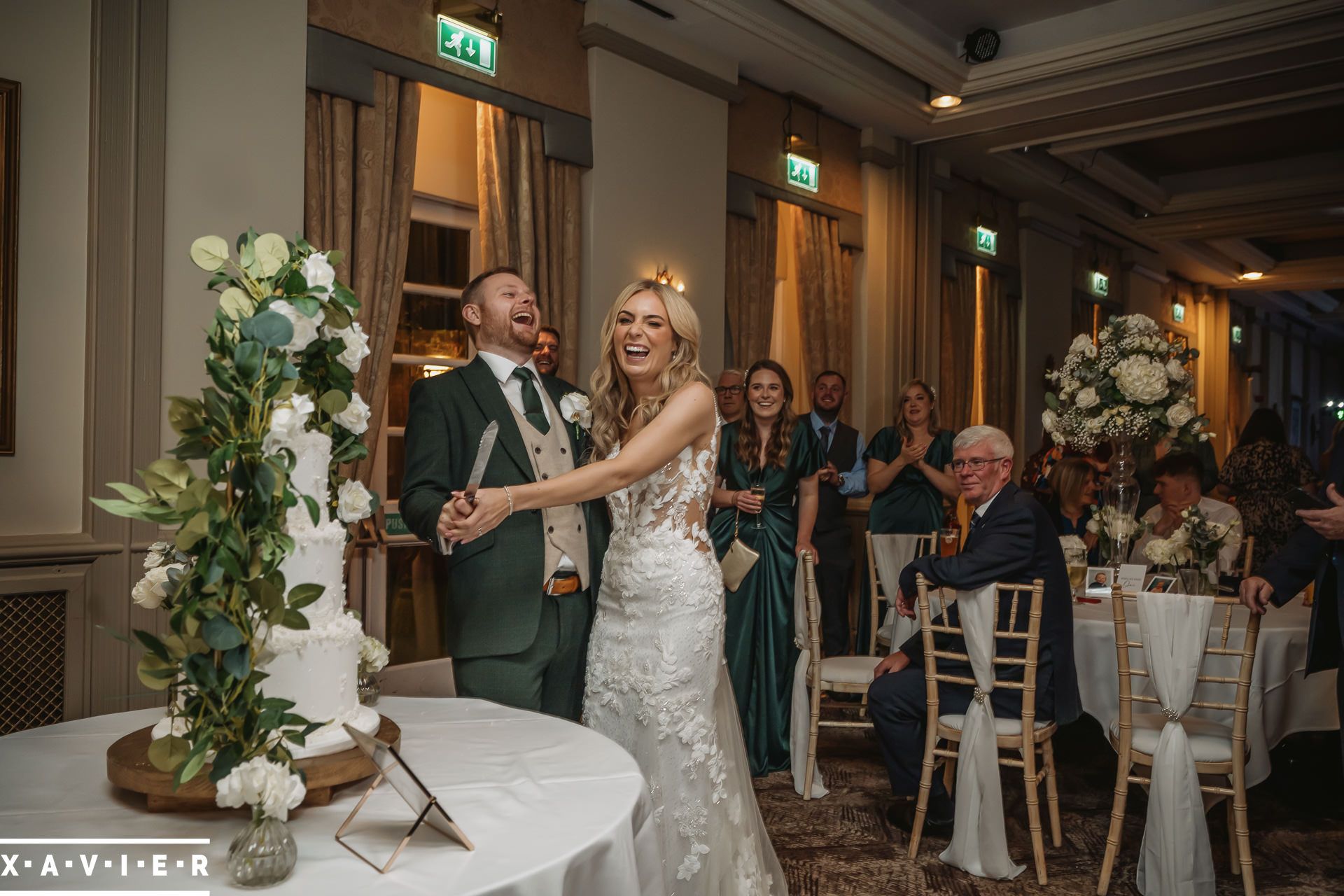 bride and groom laughing as they cut the cake