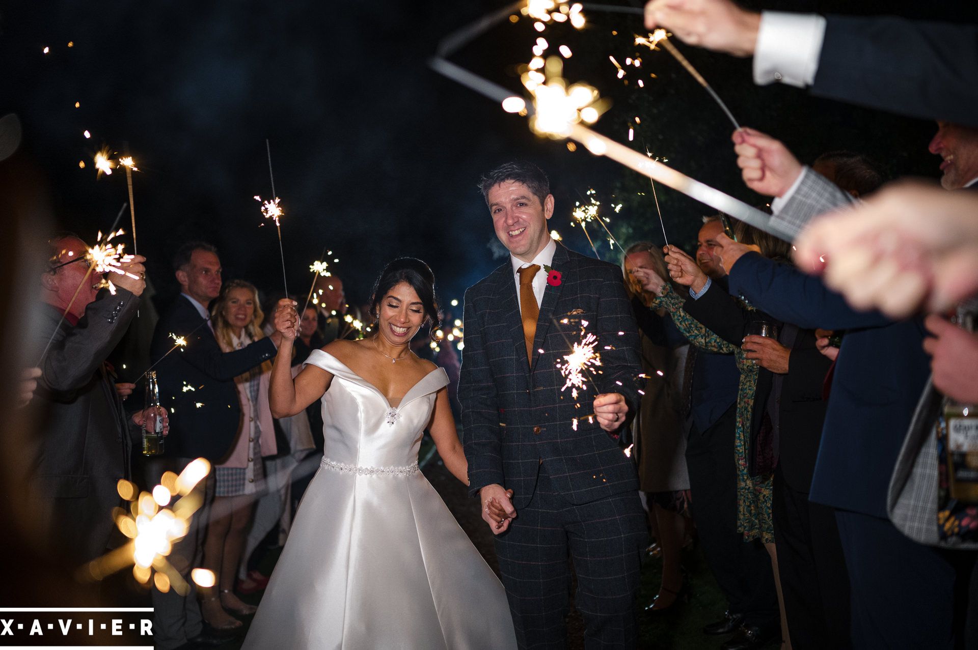 bride and groom walk through sparklers