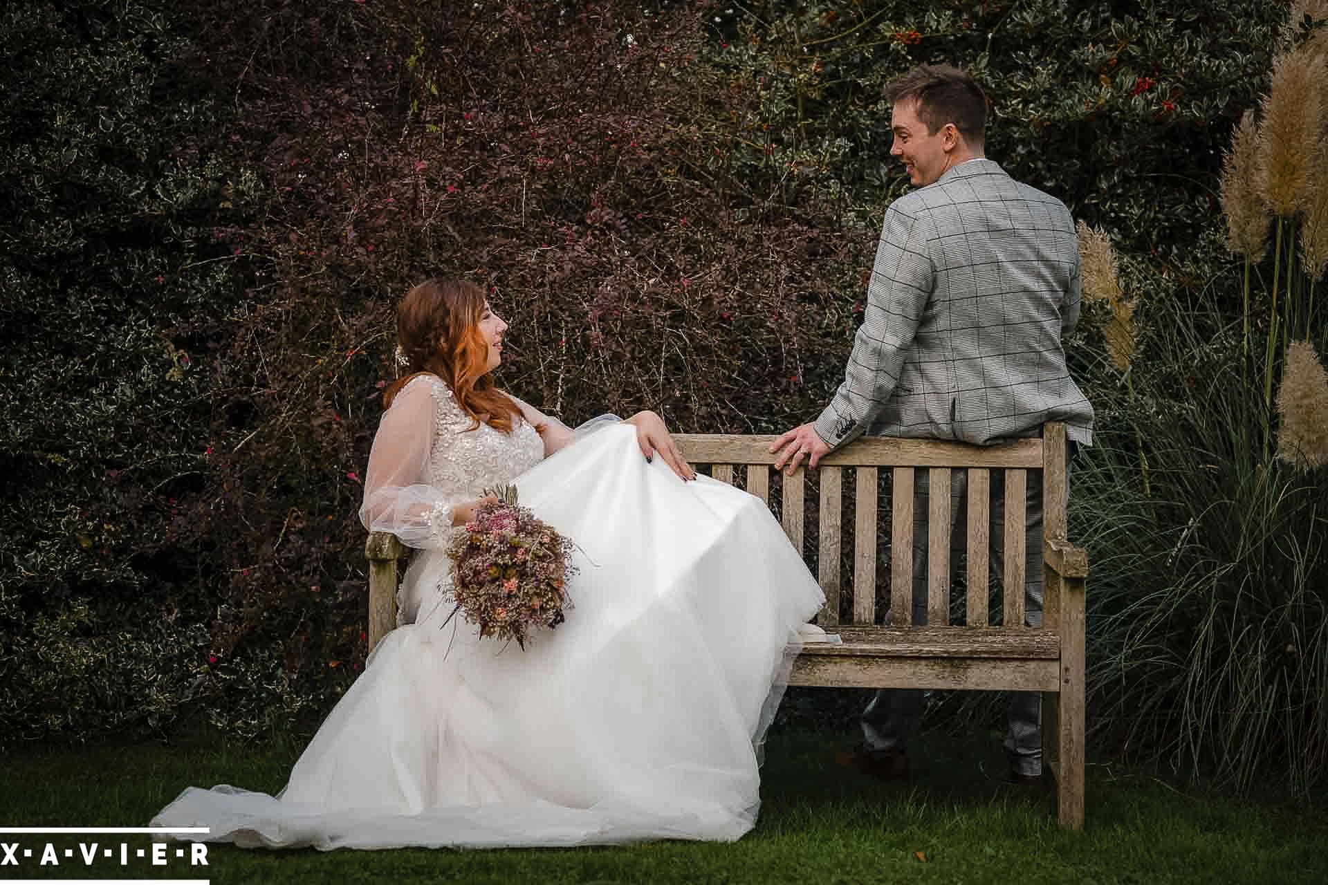 bride and groom sitting on a bench