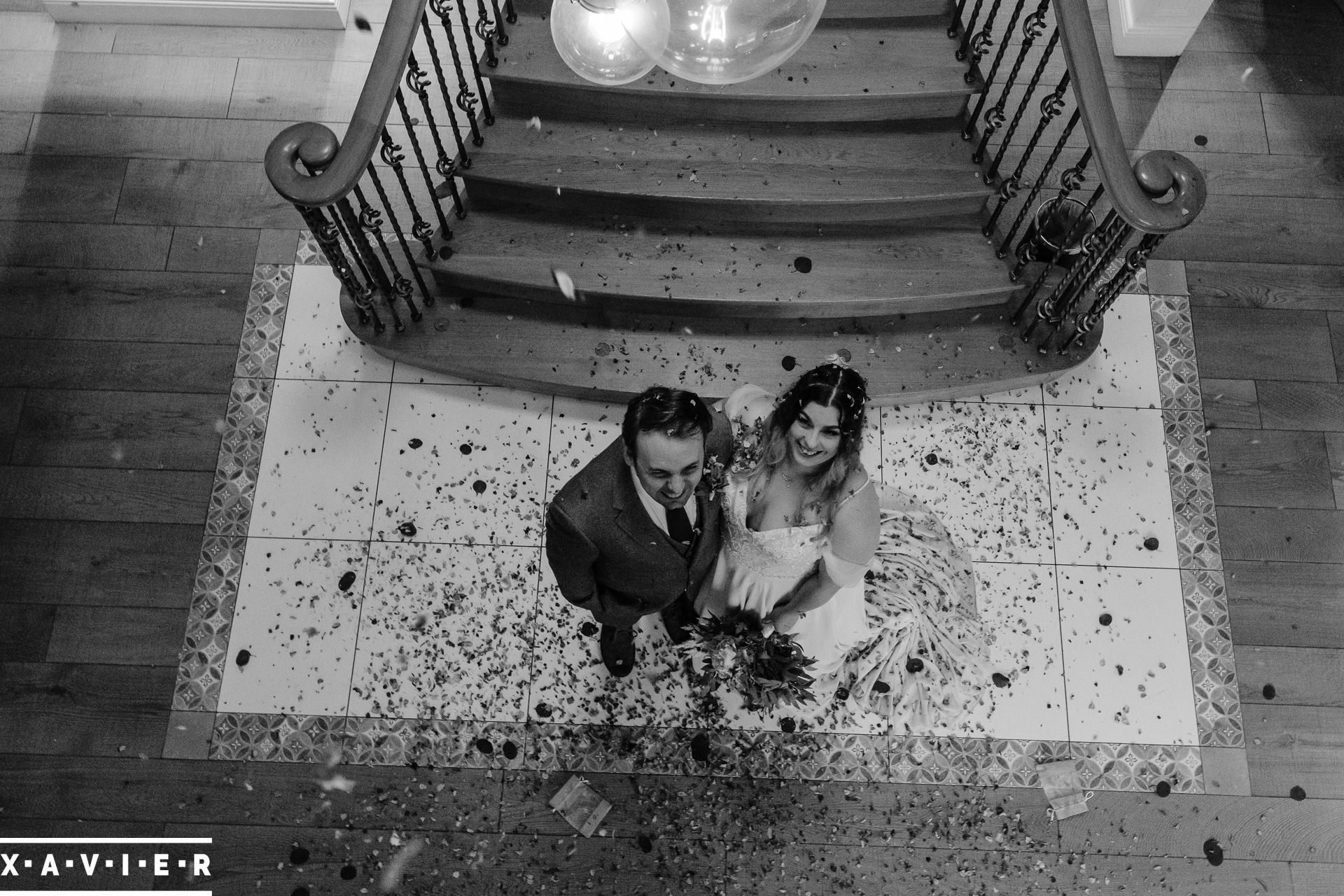 Bride and groom standing as confetti fall on them from above