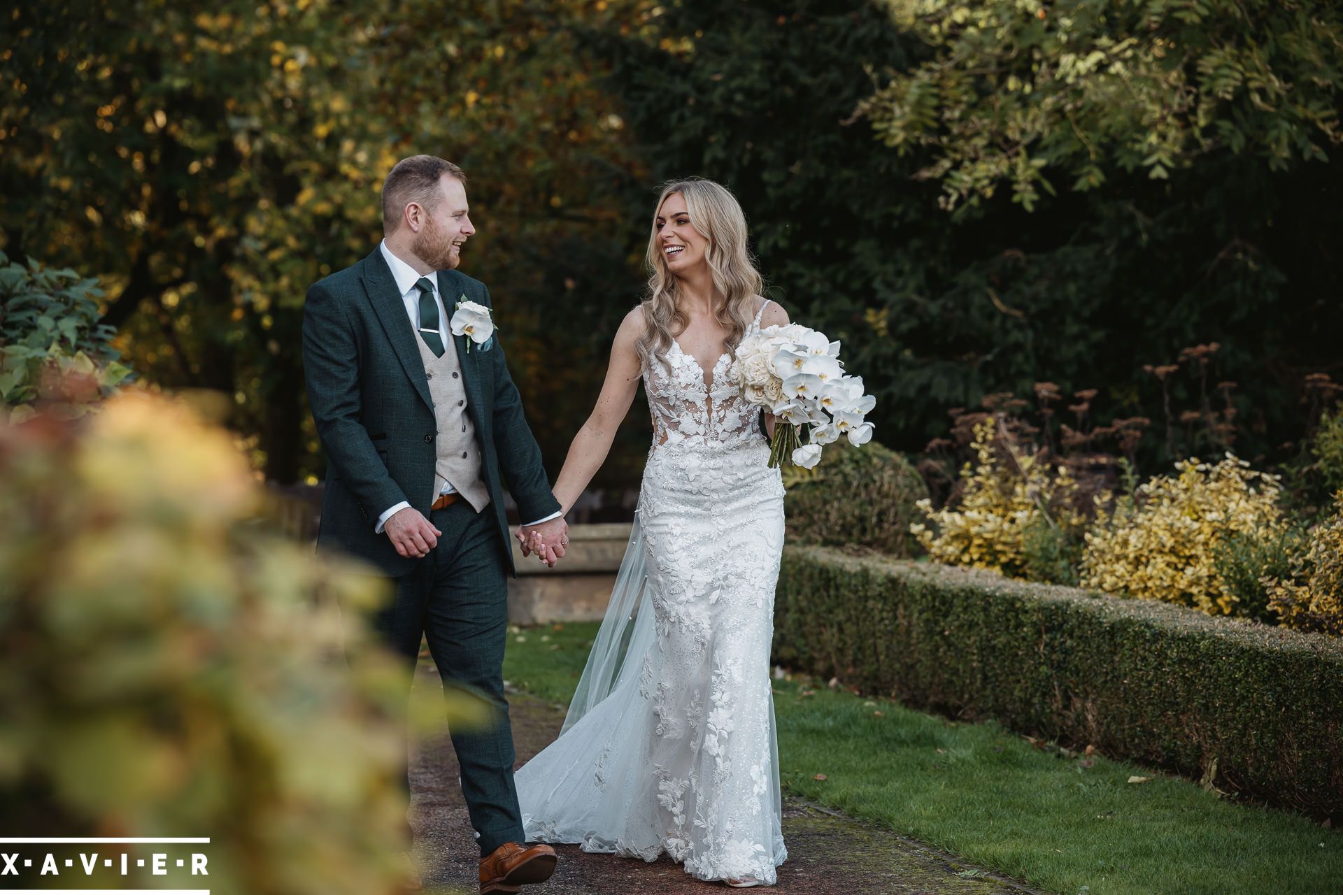 bride and groom walking in the groundsof oulton hall