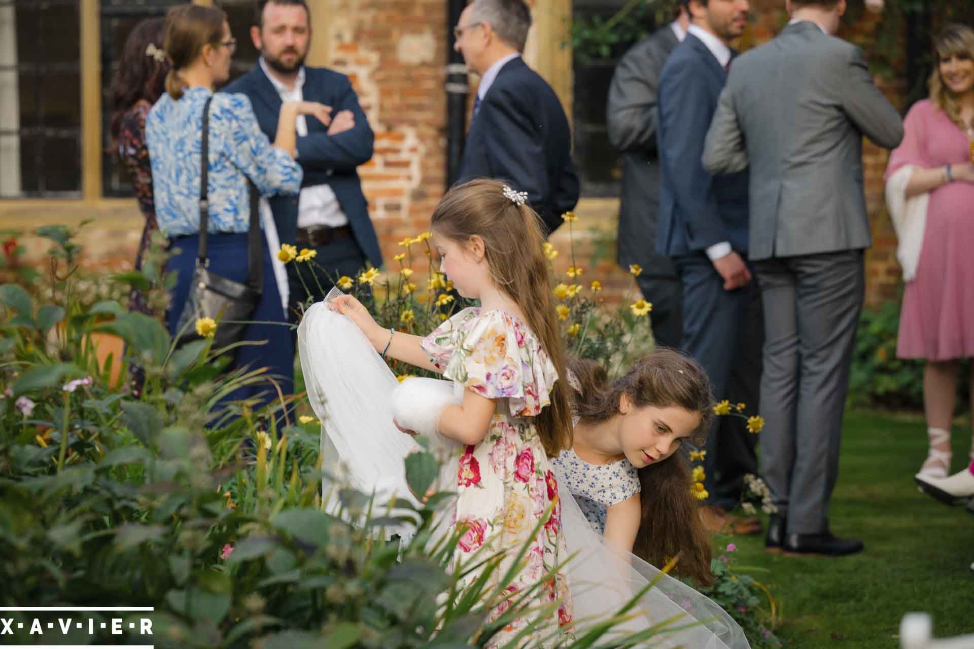 Flowergirls have the brides veil in the courtyard