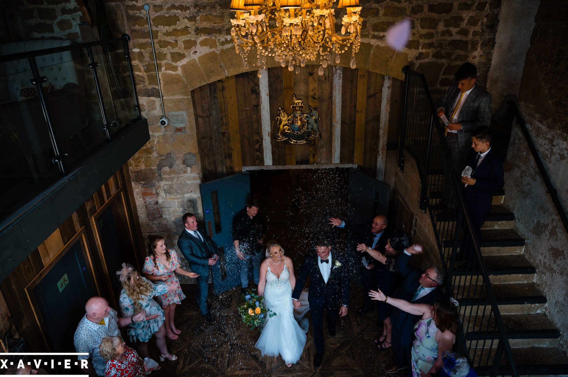 a crowd gathers to throw confetti on the bride and groom