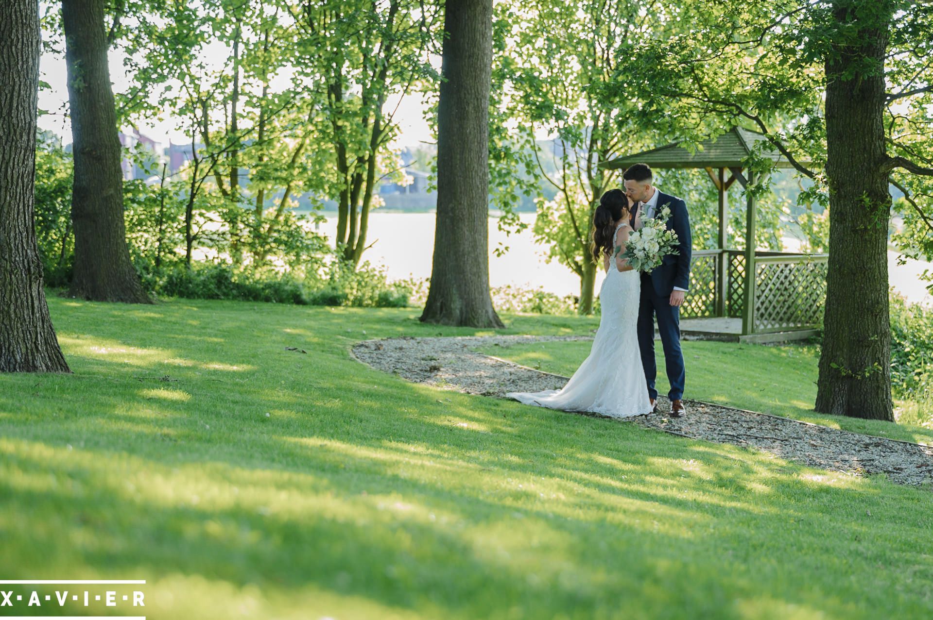 Bride and groom stop on the path for a kiss 