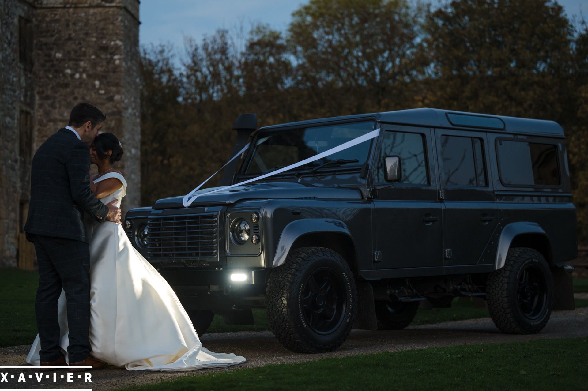 bride and groom kiss in front of land rover defender