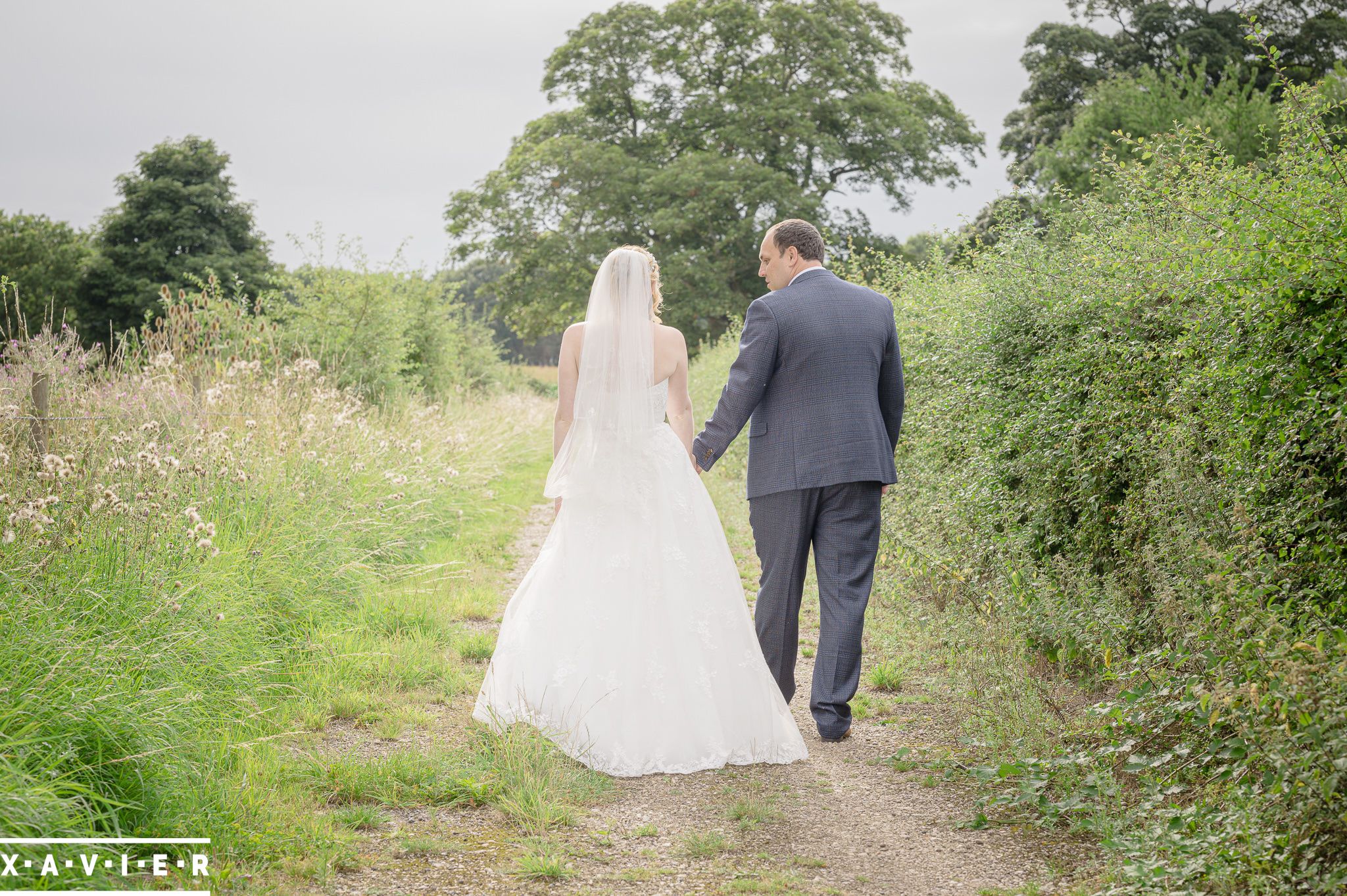 bride and groom walk along the fields