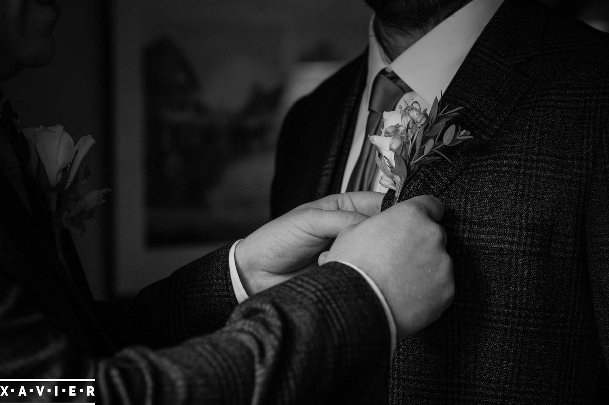 best man fastens the grooms button hole flower