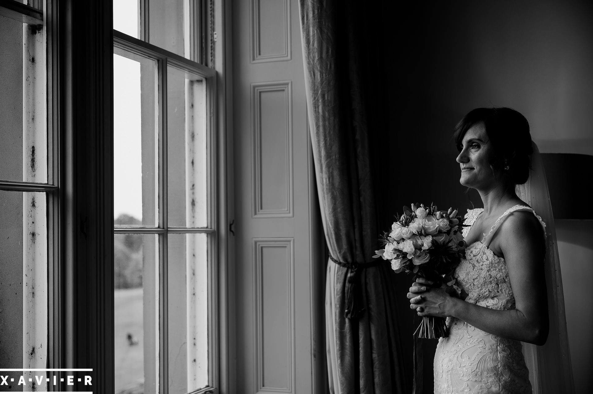 bride holding flowers by the window