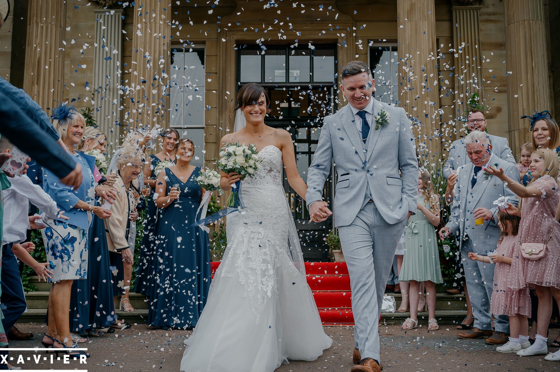 bride and groom walk through the confetti