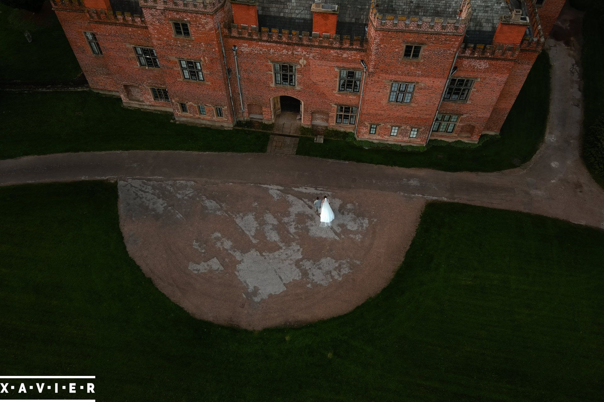 Ariel view of bride and groom walkig towards Holme Pierrepont Hall