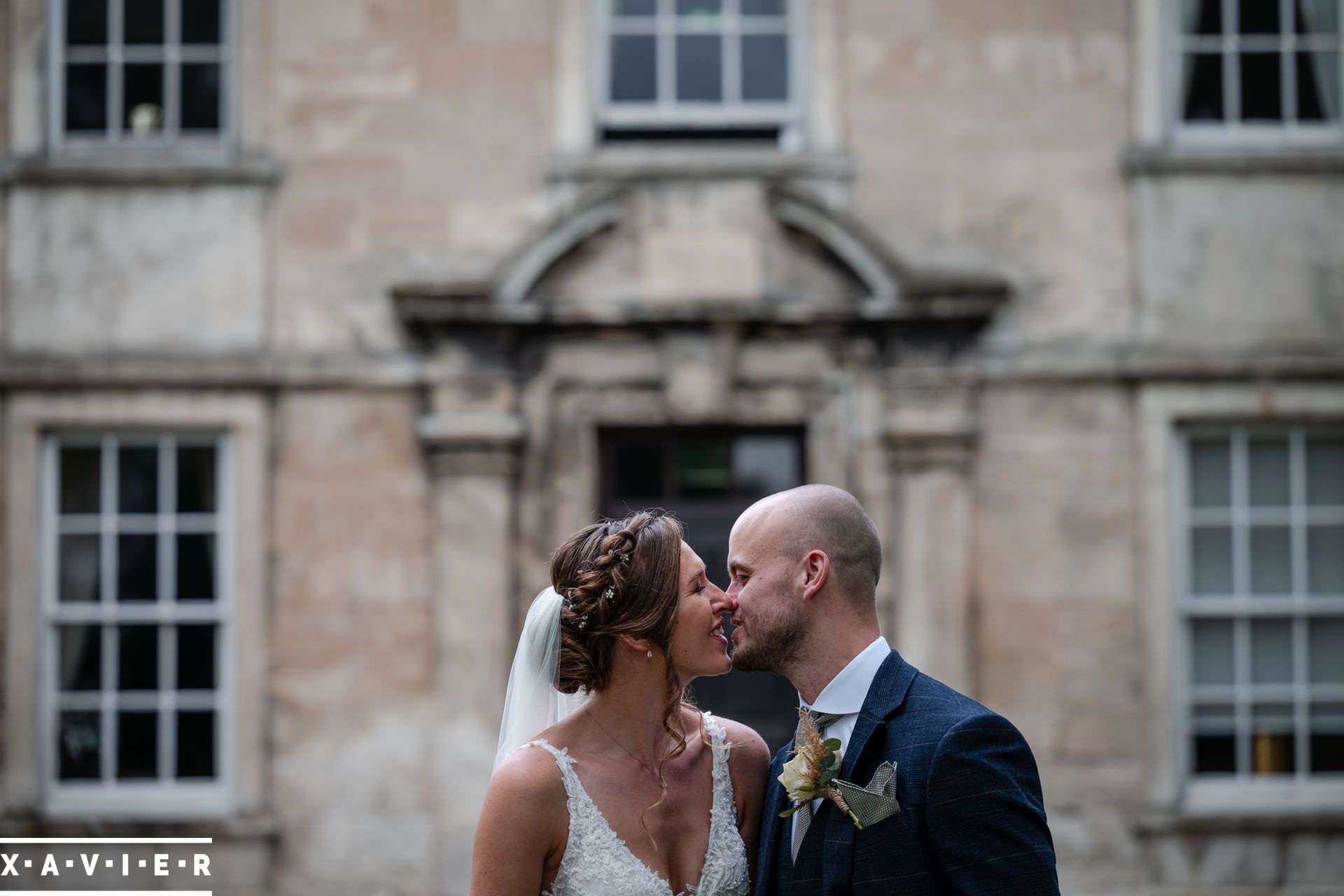 bride and groom kiss in front of the wedding venue