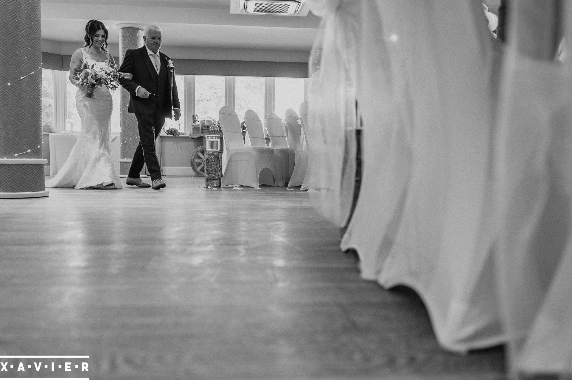 father leads his daughter down the aisle