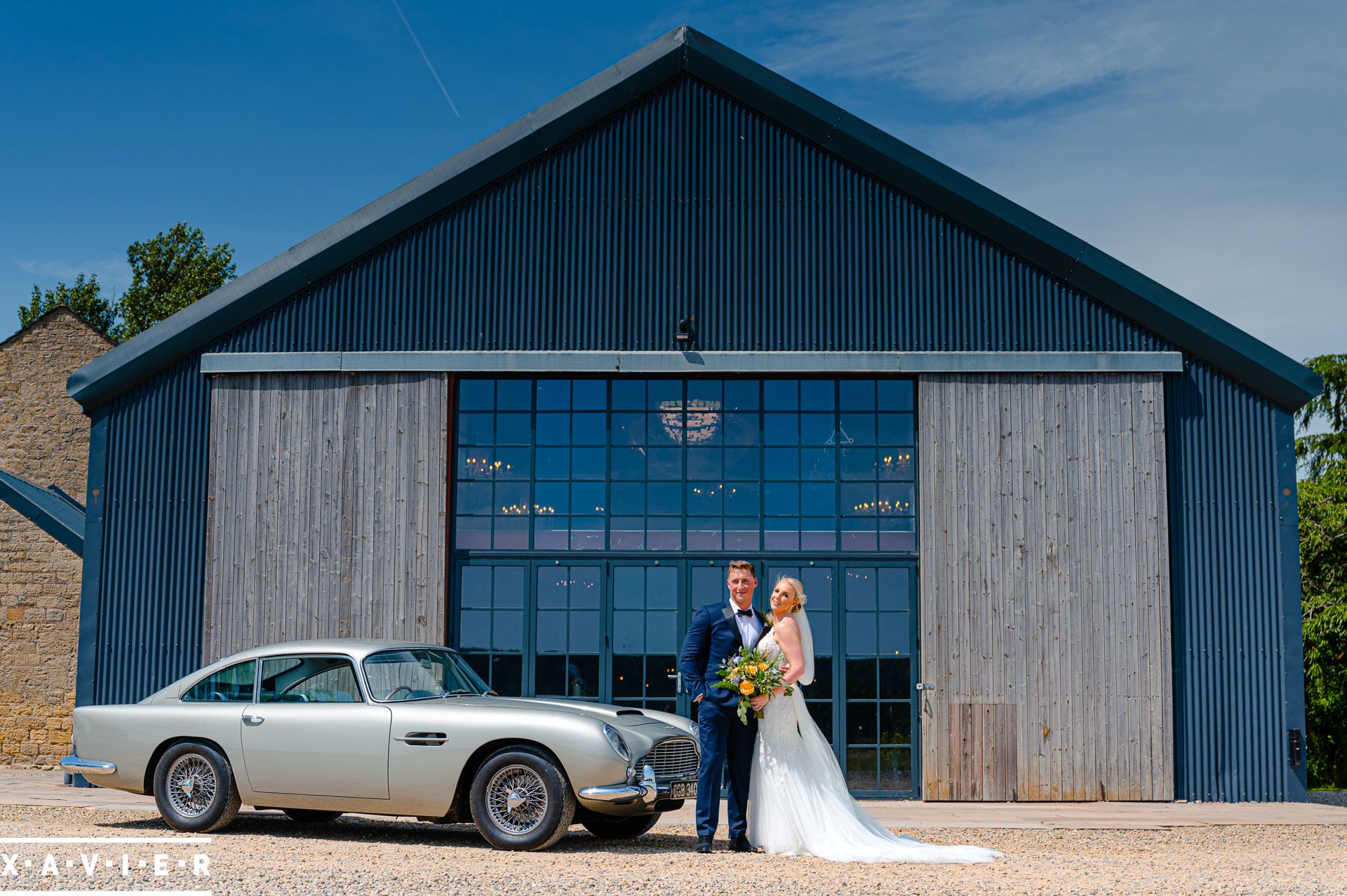 Bride and groom stand next to aston martin db5