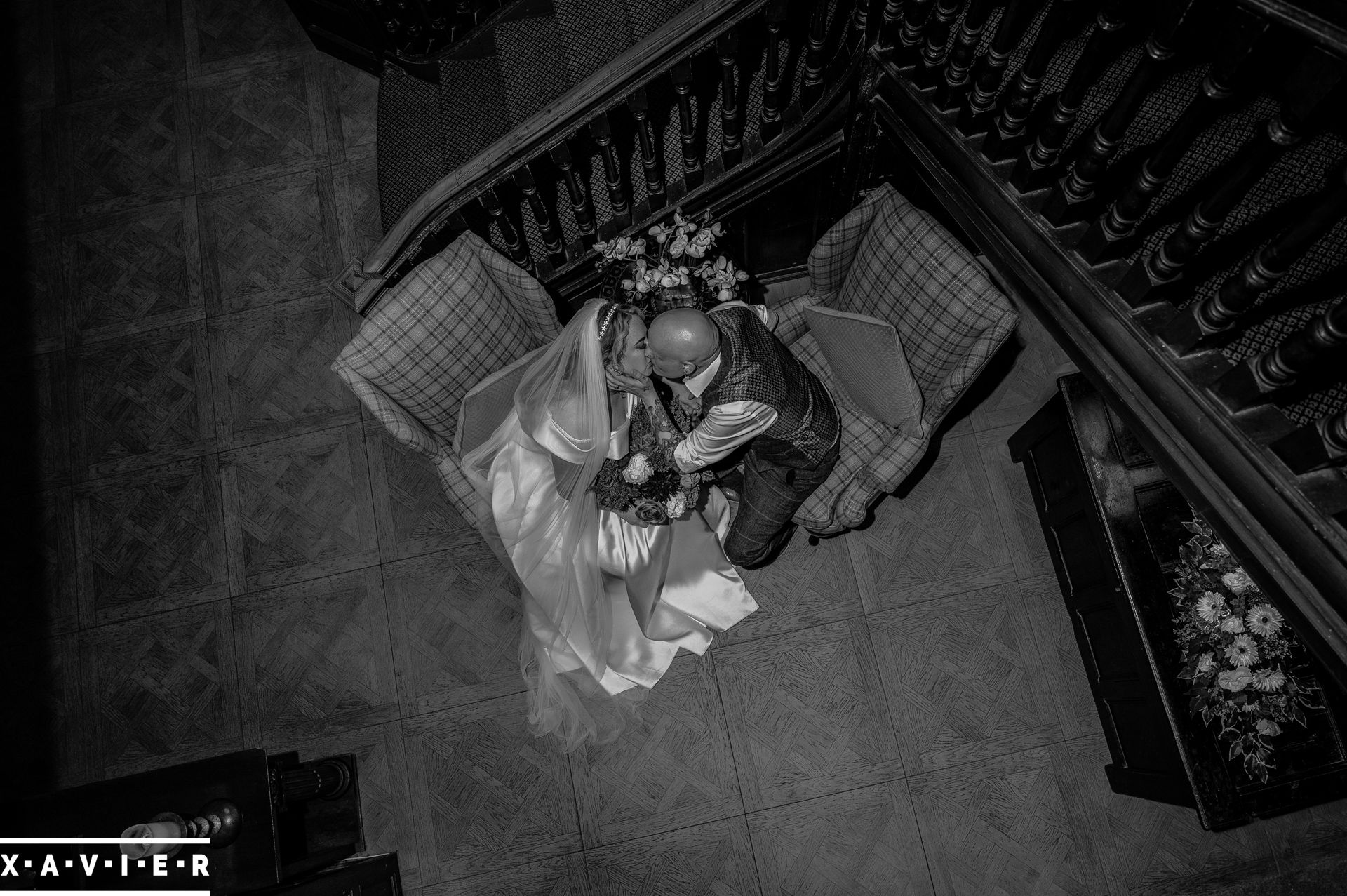 black and white photo looking down at bride and groom kissing 