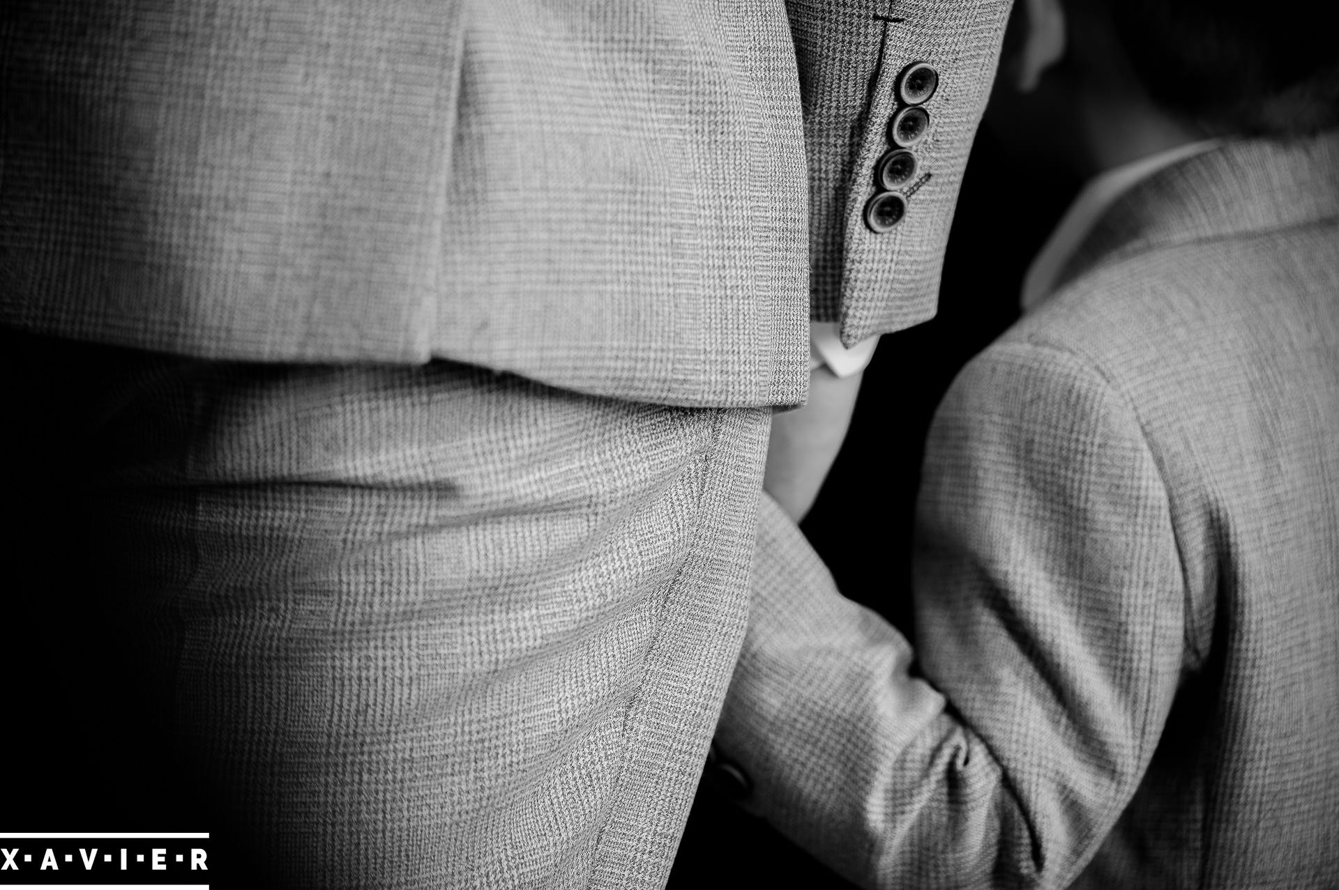 close up of groom holding page boys hand